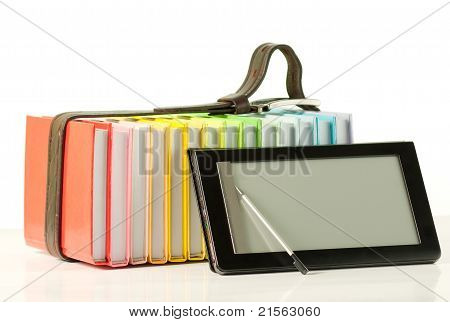 Pile de livres colorés et de lecteur de livre électronique sur le fond blanc