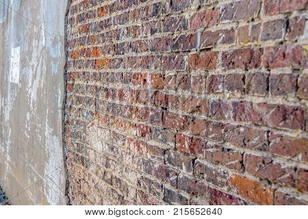 Perspective view of an old grungy red brick wall in an alley