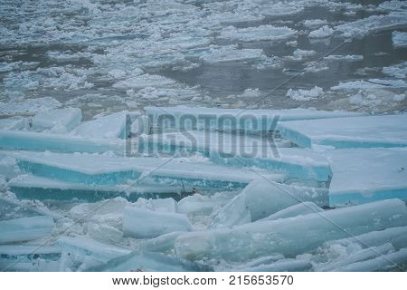 Winter ice block background new year. Background with cracked ice frozen texture. Frost crystal icy Christmas backdrop. Texture of spring melt snow on water. Christmas frozen glacier texture.
