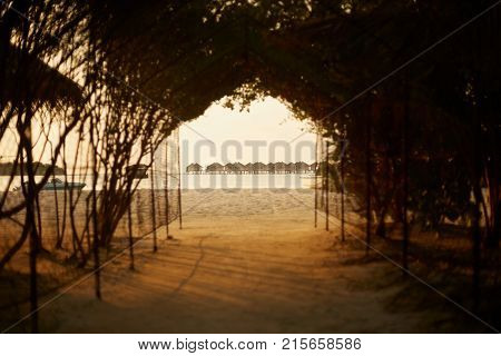 Tunnel from tropical with water bungalows on background. Luxury hotel at Maldives island. Spa resort villas in Indian ocean.