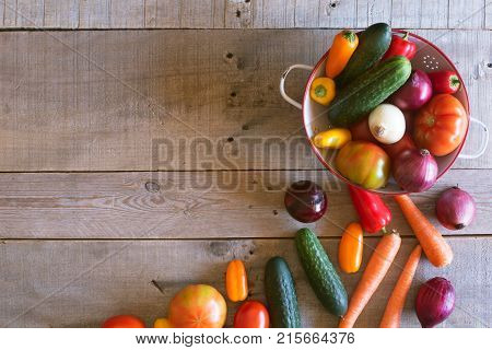 Fresh vegetables in a metallic bowl on a wooden background. Top view