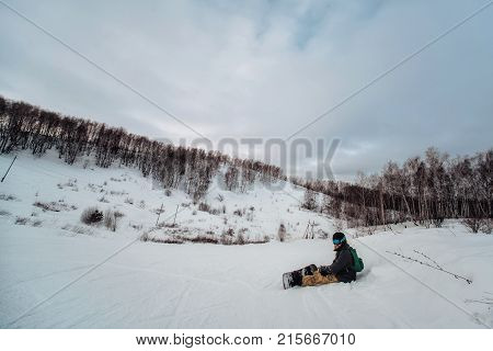 Snowboarder In A Black Helmet Riding On A Snowy Track.
