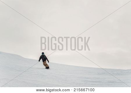 Snowboarder In A Black Helmet Riding On A Snowy Track.