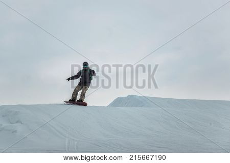 Snowboarder In A Black Helmet Riding On A Snowy Track.