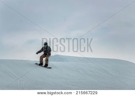 Snowboarder In A Black Helmet Riding On A Snowy Track.
