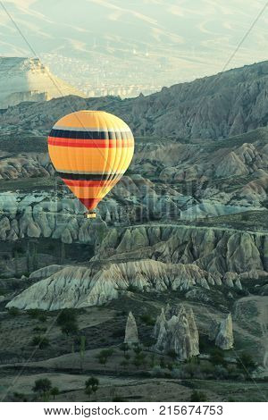 Balloon flight in the sunrise sky. Cappadocia, Turkey. Picturesque landscape with sandstone mountains