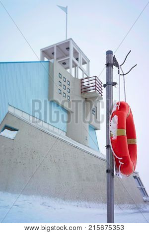 Lifebuoy and Lighthouse at the Baltic Sea in winter Oulu Lapland Finland.