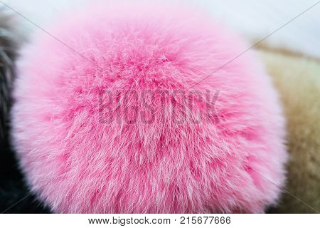Pink natural fur pompon texture. Selective focus