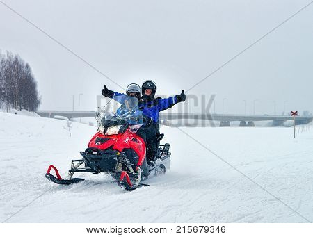 Man And Woman Riding Snowmobile In Winter Rovaniemi