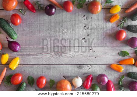 Fresh vegetables on a wooden background as a frame. Top view