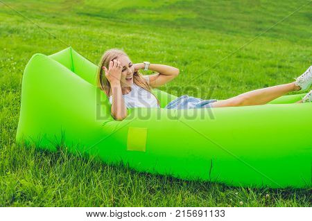 Young Woman Resting On An Air Sofa In The Park.