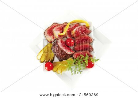 半生的牛肉肉与蔬菜在白板上