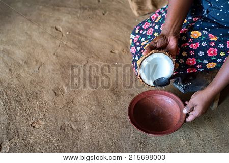 Close up woman in traditional Indian clothing holding grater for coconut to make copra