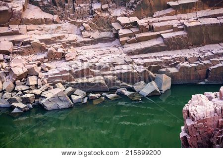 View of Indian river Ken with stones on banks and a small crocodile hiding under water