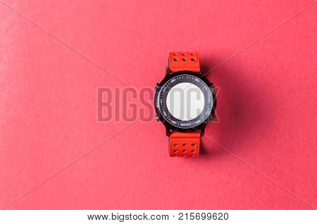 Red smartwatch on red background. Useful for business / tech / sport / any activity presentation background