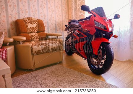 KRASNOYARSK RUSSIA - SEPTEMBER 9 2017: Red and black sportbike Honda CBR 600 RR 2005 PC37 in house. The motorcycle in the apartment. Winter storage.