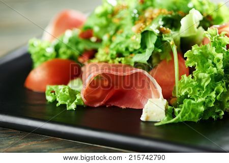 Cropped close up of sliced ham mixed with chopped greens served at the local restaurant cooking kitchen cusine people eating food nutrition delicious healthy vitamins lifestyle.