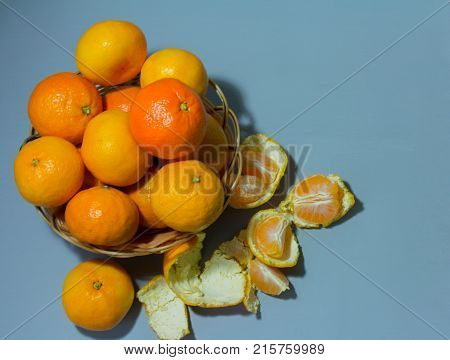 tangerines in a wicker basket on a blue background