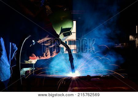 Industrial welder welding fabricated construction in factory Welding process by Flux Core Welding FCAW