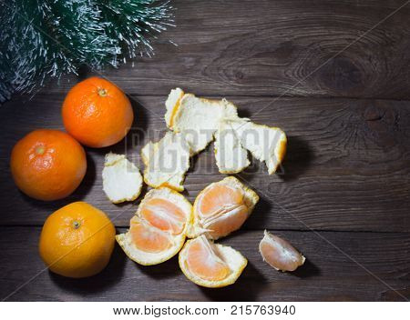 whole tangerines and slices on wooden background with selective focus
