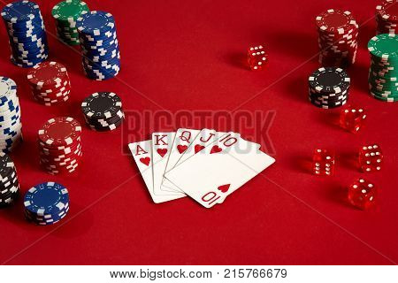Poker cards and gambling chips on red background. Top view. Copy space. Still life. Flat lay. Royal flush
