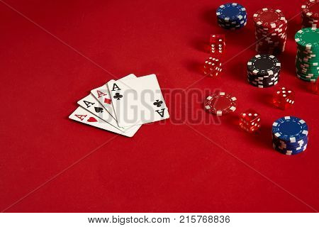 Poker cards and gambling chips on red background. Top view. Copy space. Still life. Flat lay. Cards - four aces. 4 of a kind
