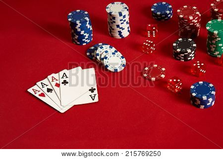 Poker cards and gambling chips on red background. Top view. Copy space. Still life. Flat lay. Cards - four aces. 4 of a kind