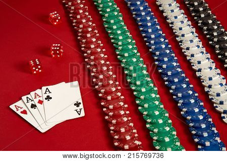 Poker cards and gambling chips on red background. Top view. Copy space. Still life. Flat lay. Cards - four aces. 4 of a kind