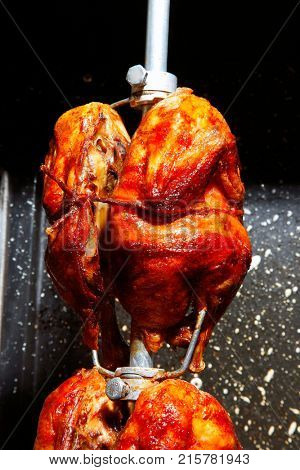 Cooking rotisserie chicken on the grill with Charcoal and Briquettes in the professional steak house or barbecue restaurant