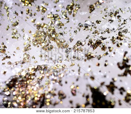 Closeup photograph of epitaxy of pyrite on calcite. Golden details. Natural phenomenon. Very abstract look.