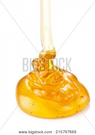 Honey rivulet running down into the honey puddle. Isolated on white background.
