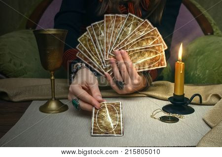 Tarot cards on fortune teller desk table. Future reading. Woman fortune teller holding and hands a deck of tarot cards and shuffles it.