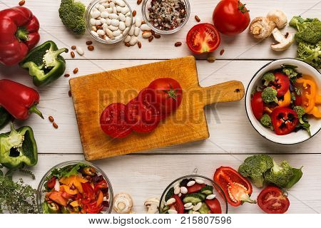 Cooking assorted vegetable salads on white wood top view. Fresh organic snack for vegetarian party food table, copy space. Mockup for menu, recipe or culinary classes, healthy eating concept