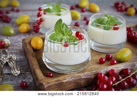 blancmange curd in a glass and fresh red currant, kumquat and mint