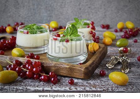 blancmange curd in a glass and fresh red currant, kumquat and mint
