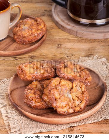 Glazed apple fritters on a wooden plate