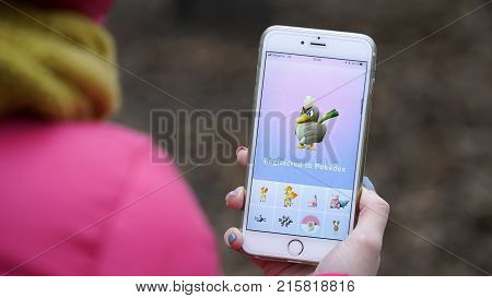 Samara, Russia - November 28, 2017: woman playing pokemon go on his iphone. pokemon go multiplayer game with elements of augmented reality.