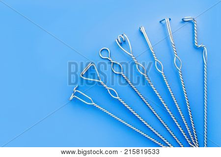 Speech therapy tools on a blue background. Logopedic metal probes. The use of special tools for speech correction