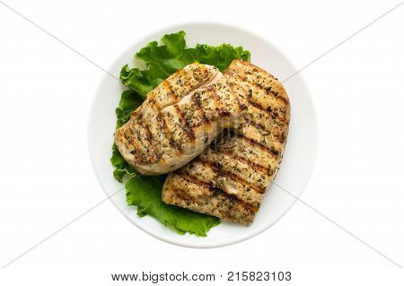 Chicken grilled steak on leaves slate on a white round plate isolated on white background. Top View. Healthy food. Diet, fitness food. B-B-Q
