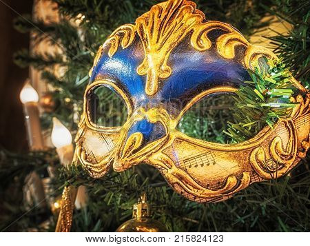 Venetian carnival mask on christmas tree. Christmas and New Year's background. Christmas tree, ball, candle, mask, Christmas decorations.