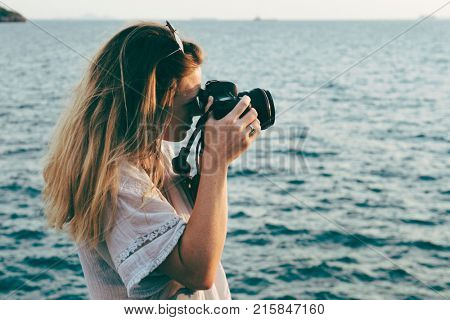 Woman with camera shooting on the beach
