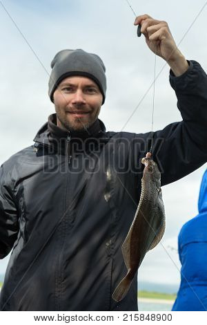 Tourist caught a flounder in the Pacific Ocean near the Kamchatka Peninsula