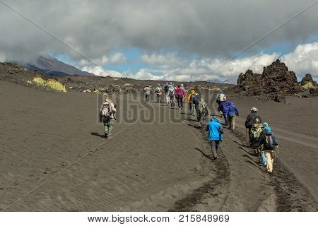 Kamchatka Peninsula, Russia - August 21, 2016: Group of tourists walks on the Lava field at the Tolbachik volcano, after eruption in 2012