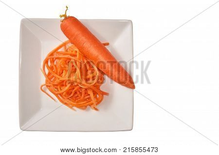 Grated and whole carrots in a white cup on a white background. Isolate.