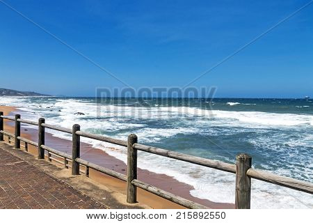 Wooden Pole Barrier On Beachfront Against Coastal  Landscape