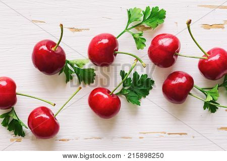 Close up fresh cherries on white rustic wood table in top view flat lay with copy space. Cherry background suitable for web cover or banner. Cherry have high vitamin and have sweet and sour taste. Fruit background concept of fresh cherry.
