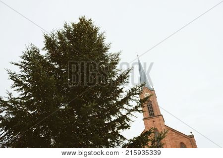 Majestic Christmas tree with yellow illumination and Friedenskirche church in Marktstrasse view from below