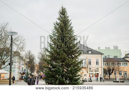 KEHL GERMANY - DEC 13 2016: Tall Christmas Tree in central Kehl in Baden-Wurtemberg with pedestrians walking nearby during December holiday season