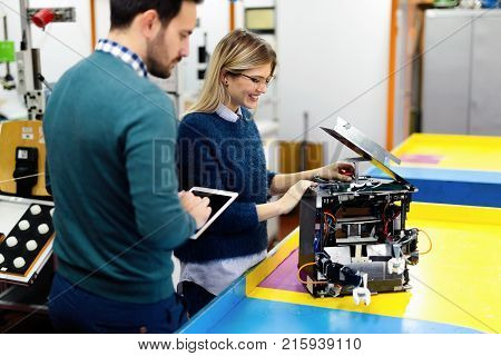 Young attractive students of mechatronics working on project together