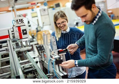 Young attractive students of mechatronics working on project together